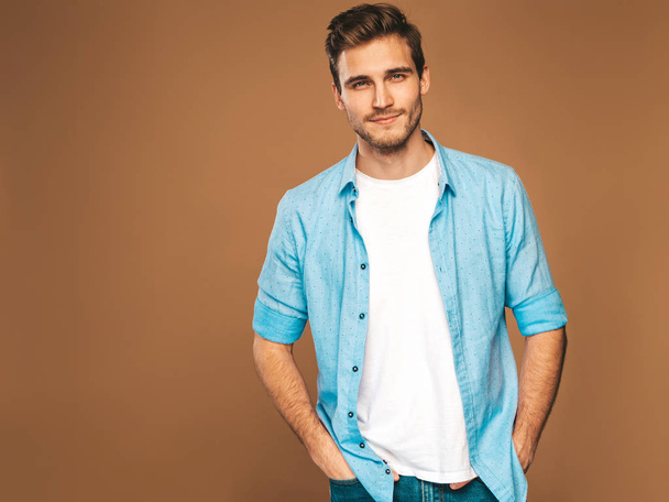 Portrait of handsome smiling stylish hipster lumbersexual businessman model dressed in jeans clothes. Fashion man. Posing on golden background - Foto, Imagem