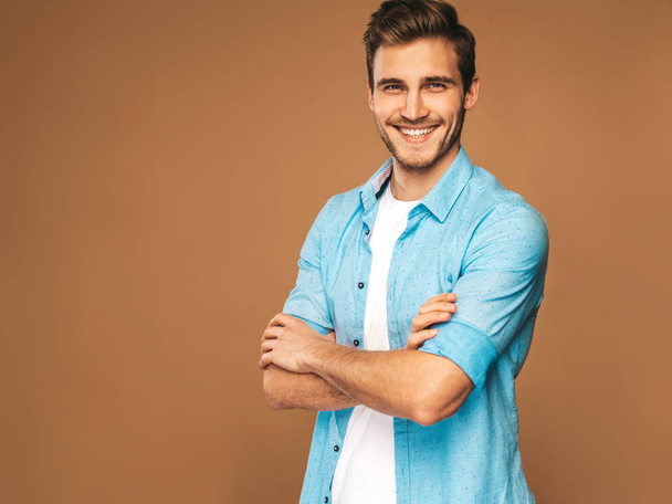 Portrait of handsome smiling stylish hipster lumbersexual businessman model dressed in jeans clothes. Fashion man. Posing on golden background - Photo, Image