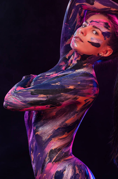 Portrait of woman with colorful body art painted different colors. Inspired dance to music. An amazing woman with art fashion makeup. - Foto, Bild