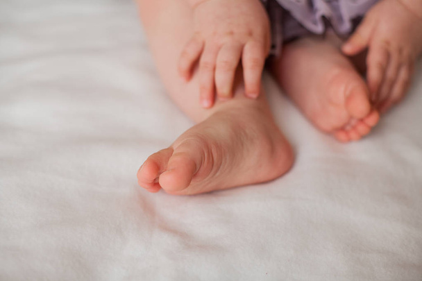 Close-up. Baby feet and handles 10 months. Cozy. Care. Home. - 写真・画像