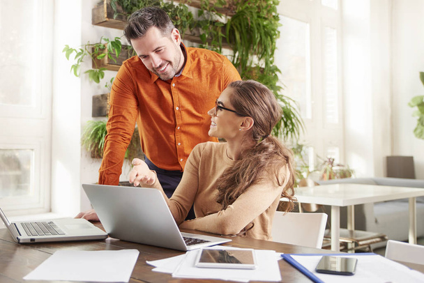 Shot of beautiful young businesswoman and financial assistant businessman working together in the office on new business plan. Teamwork in the office.  - Фото, зображення