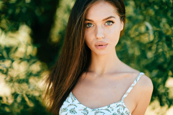 portrait of beautiful young woman with green leaves around - Foto, Imagen