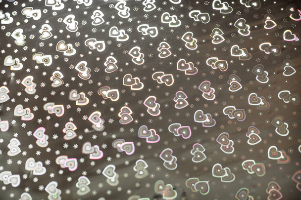 Hologramm mit Herzen, Hintergrund zum Valentinstag oder einer Hochzeit. Hintergrund mit Herzmuster auf Packpapier. - Foto, Bild