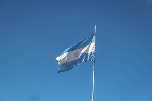 Bandera Argentina ondeando sobre un cielo azul
 - Foto, Imagen