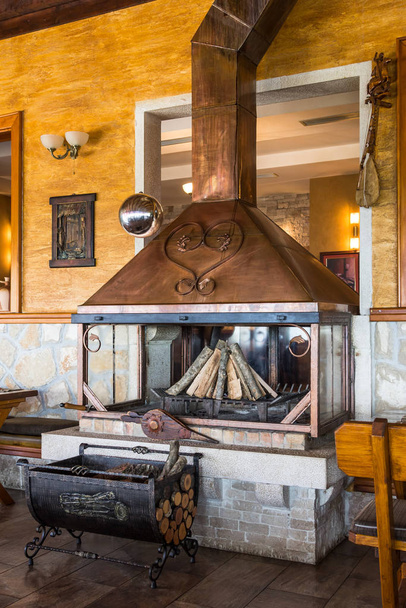BOGETICI, MUNICIPALITY NIKSIC, MONTENEGRO, AUGUST 08, 2014: Beautiful stylish brass fireplace in the Koliba Bogetici restaurant - Фото, изображение