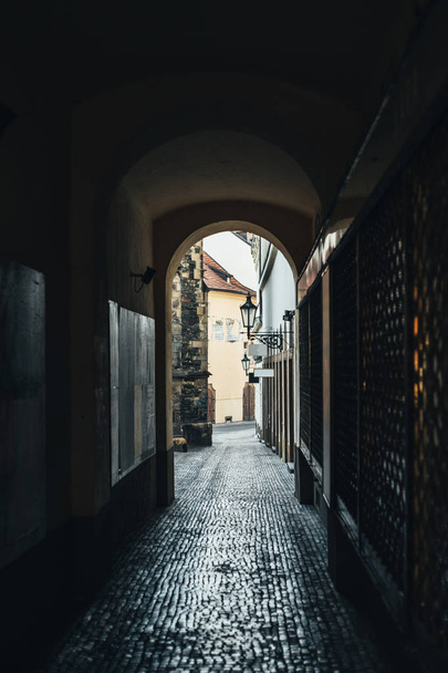 Strada stretta scura nell'arco di Praga con pavimentazione in pietra
  - Foto, immagini