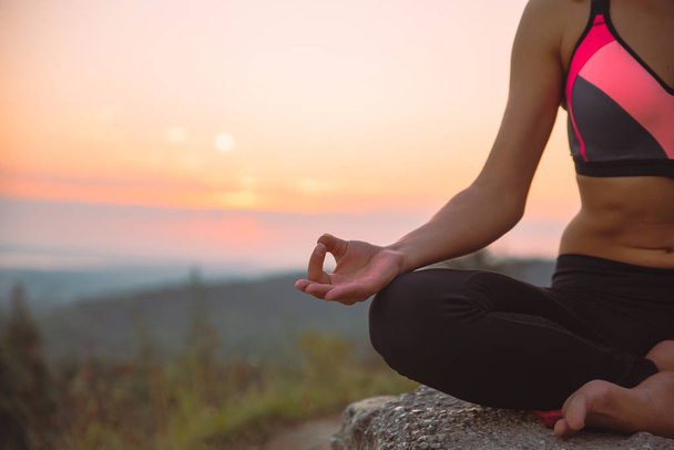 Frau macht Yoga-Übungen oben auf dem Hügel bei Sonnenaufgang. Lifestylekonzept - Foto, Bild