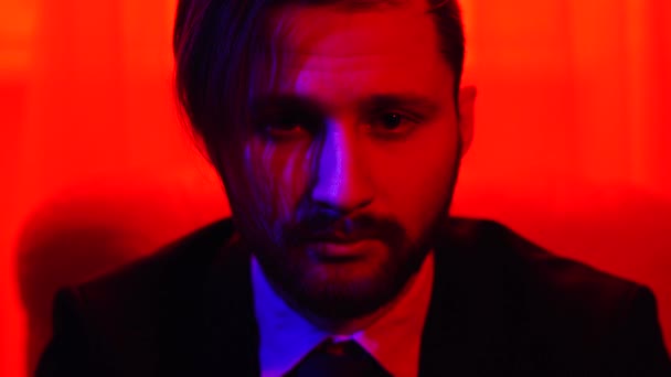 Portrait of bearded man looking in camera. Shooting in red light - Video, Çekim