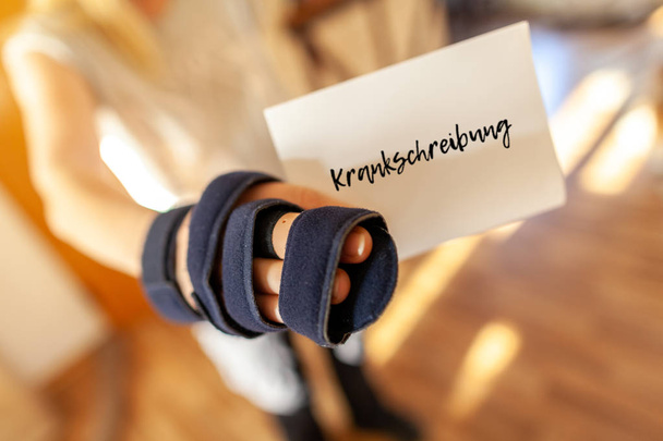 German medical certificate in a injured right hand. Krankschreibung means medical certificate - 写真・画像