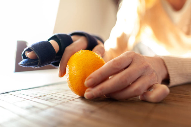 eine Hand schält eine Orange mit einem medizinischen Handtuch - Foto, Bild