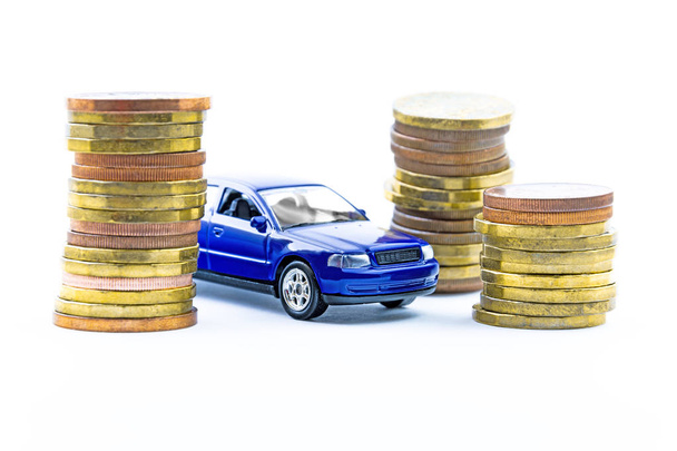 Model of blue car and coins on a white background. Isolated toy car and money. Financial concept. Buy a new or old car. - Φωτογραφία, εικόνα