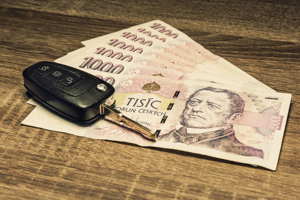 Car keys and banknotes as the concept of buying or renting a car. Loan for buying a car. Czech money at the table. Financial concept with money. - Photo, Image