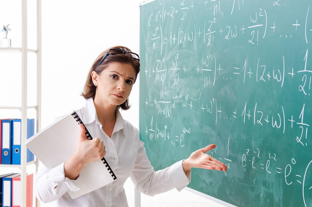 Учительница математики перед доской
  - Фото, изображение