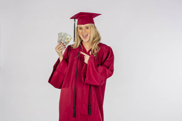 Een prachtige blonde model poseren met geld na afstuderen - Foto, afbeelding