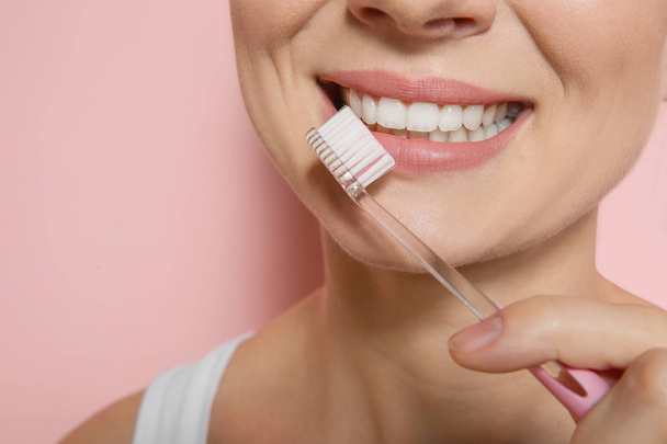 Woman with toothbrush on color background, closeup. Space for text - Foto, afbeelding