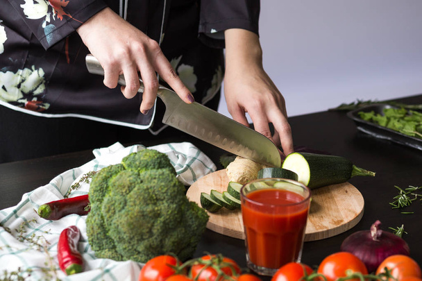 chica corta verduras con un cuchillo en la cocina
 - Foto, Imagen