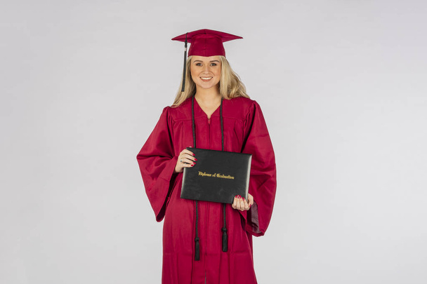 A gorgeous blonde model posing with a diploma after graduation - Photo, Image