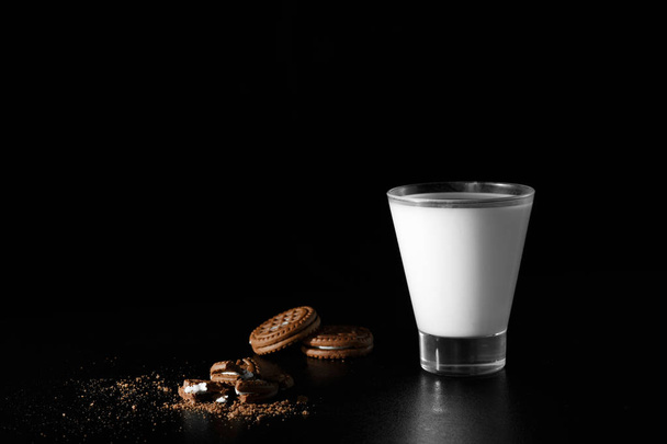 Glass of milk and chocolate cookies on black background. - Photo, Image