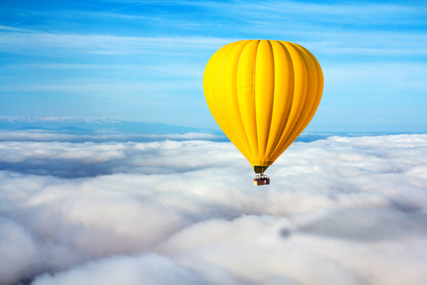 Un solitario globo de aire caliente amarillo flota sobre las nubes. Líder conceptual, éxito, soledad, victoria
 - Foto, Imagen
