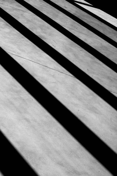 Composición geométrica con sombras que crean una perspectiva diagonal mínima en blanco y negro en interiores
 - Foto, Imagen