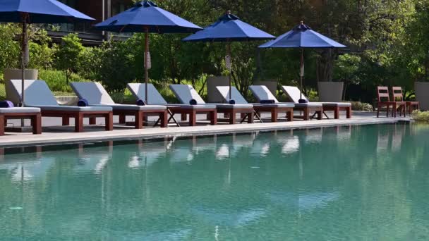 Cadeiras de praia 4K perto de piscina em resort tropical
 - Filmagem, Vídeo