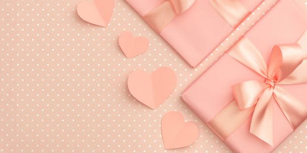 Dekoration Valentinstag auf Tischplatte Ansicht. flach legen Zusammensetzung der Form Herz und rosa Geschenkbox mit Band auf lebenden Korallen Hintergrund - Foto, Bild