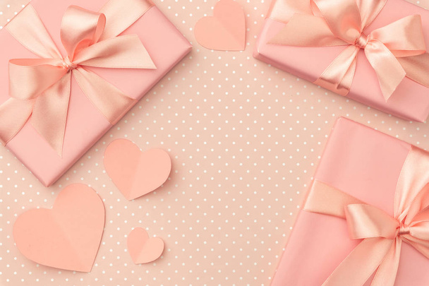 Valentine day decoration gift box with ribbon and small coral hearts on living coral background. Top view. Love day concept flat lay - Fotoğraf, Görsel