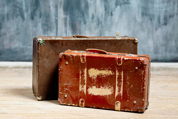 Two brown shabby suitcases near a dark wall in chalk - Foto, Imagen