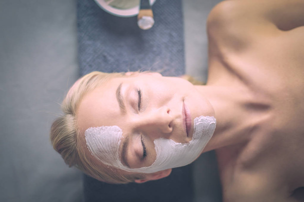 Mascarilla facial. Hermosa joven en el spa, mujer cosmética aplicando mascarilla facial
. - Foto, imagen