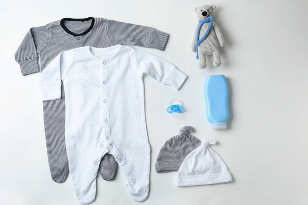 Composição de leigos planos com roupas de bebê e acessórios em fundo branco - Foto, Imagem