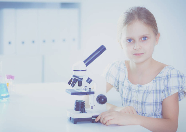 Schoolgirl looking through microscope in science class. - Fotoğraf, Görsel