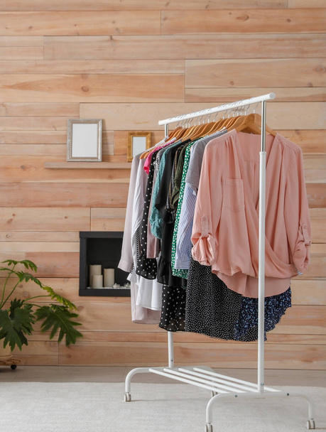 Wardrobe rack with stylish clothes in dressing room - Фото, зображення