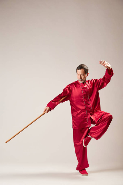 Senior master practicing qi qong taijiquan at studio. Breathing exercise and martial art moves, traditional chinese qi energy management gymnastics - 写真・画像