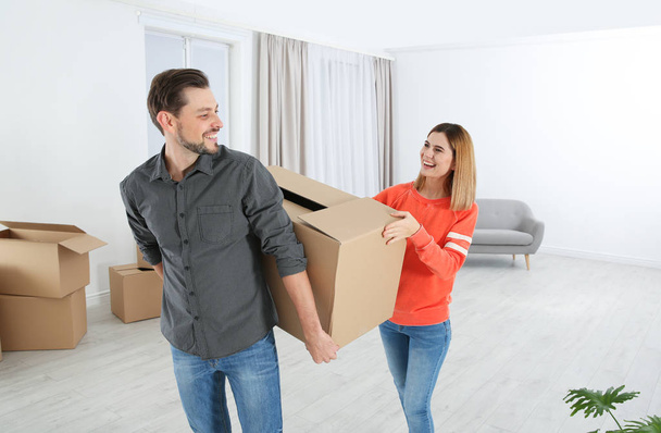 Couple with moving box in their new house - Foto, afbeelding