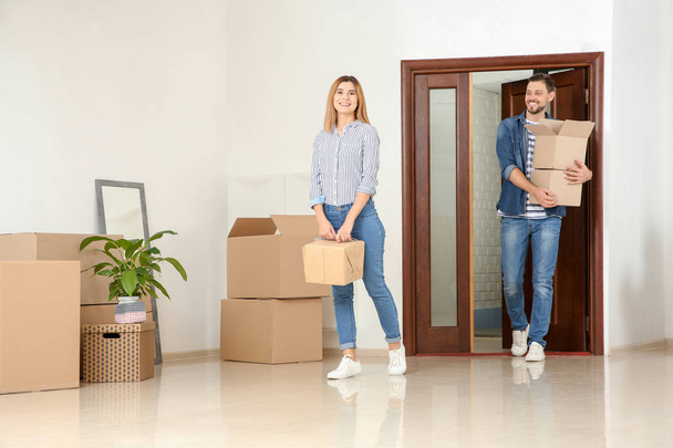 Couple walking into their new house with moving boxes - Foto, Imagem