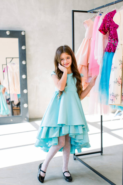 The lovely little girl posing in a beautiful blue dress. - Fotó, kép