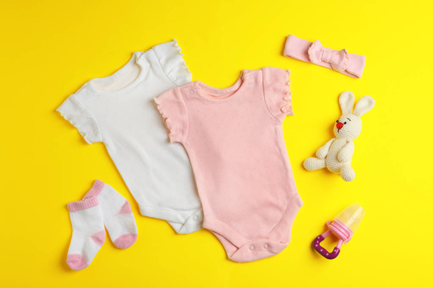 Flat lay composition with cute clothes on color background. Baby accessories - Фото, изображение