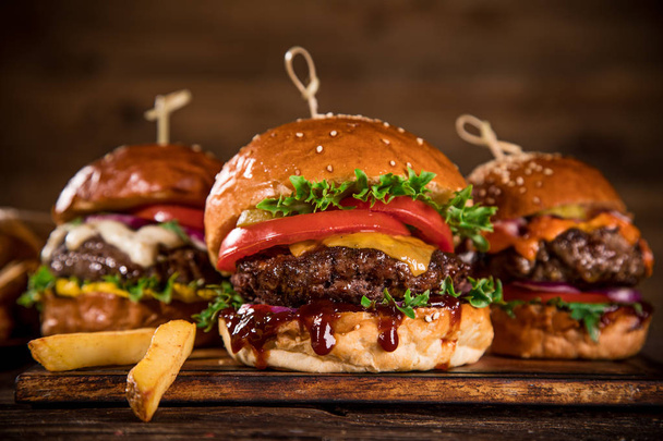 Tasty burgers on wooden table. - Photo, image