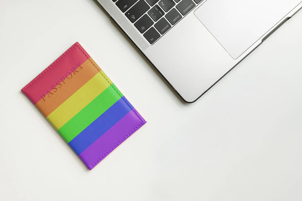 LGBT flag on passport, dildo and laptop on white desk with copy space. LGBT travel concept. Searching tickets online for dating. - Photo, Image