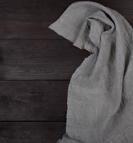 γκρι λινό πετσέτα σε καφέ ξύλινο φόντο, κενό χώρο - Φωτογραφία, εικόνα