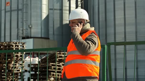 zaměstnanec s mobil počítání eurobankovek v blízkosti továrny - Záběry, video