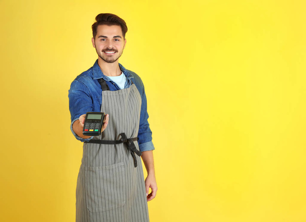Waiter with payment terminal on color background. Space for text - Photo, image