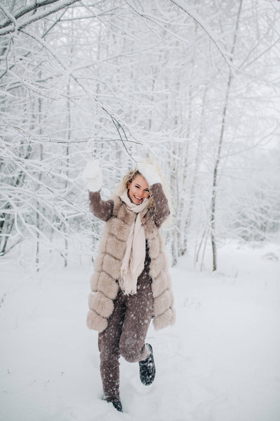 Photo of blonde woman on walk in winter forest - Foto, afbeelding