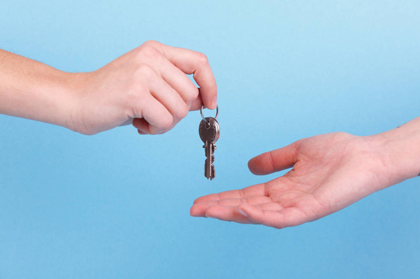 Anahtarı elinde ev. El tutma palmiye ve anahtar üstünde parmak kadar evde - Fotoğraf, Görsel