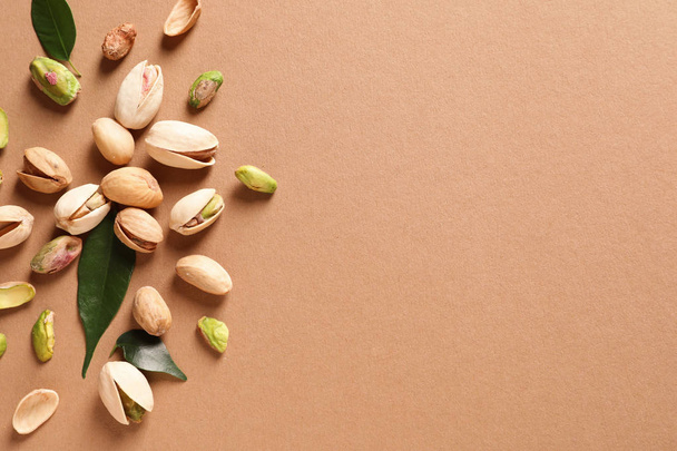 Composition with organic pistachio nuts on color background, flat lay. Space for text - Φωτογραφία, εικόνα