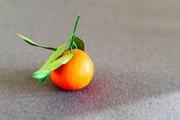 Fresh tangerine or mandarin fruit on grey background - Фото, изображение