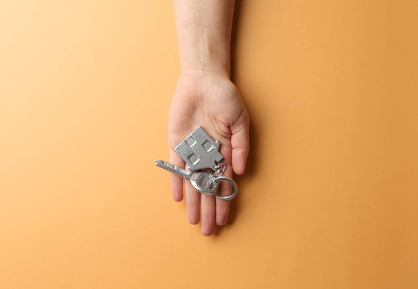 Female hand with key on color background. Mortgage concept - Valokuva, kuva