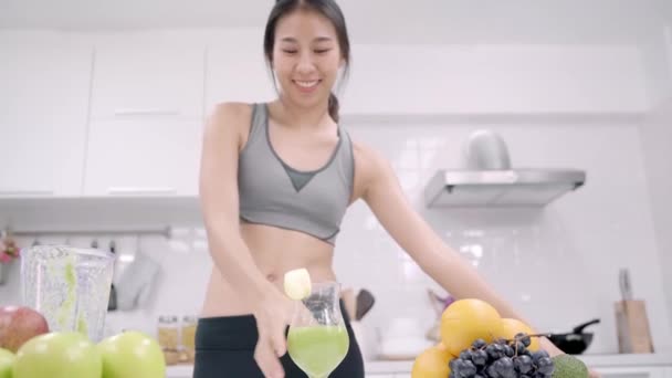 Jonge Aziatische blogger vrouw met behulp van smartphone foto post in de sociale media in de keuken, vrouwelijke in sport kleding maken salade thuis. Levensstijl vrouwen ontspannen thuis concept. - Video