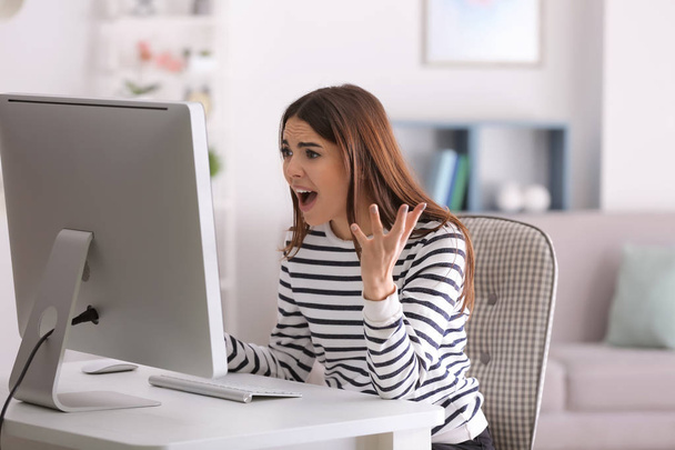 Emocjonalne młoda kobieta gra na komputerze w domu - Zdjęcie, obraz