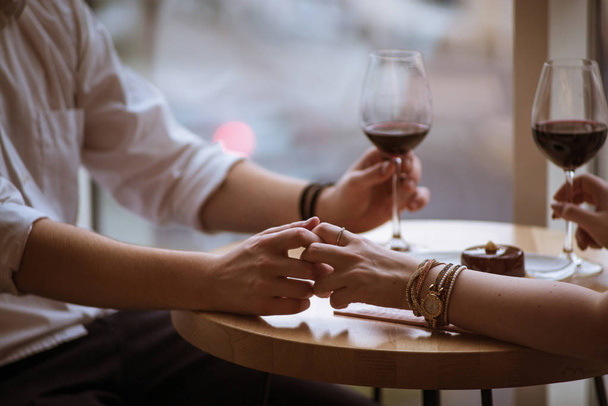 Erkek ve kız bir kafede, evlenme teklifi ellerini tutun - Fotoğraf, Görsel